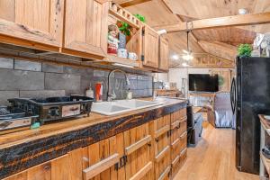 een keuken met houten kasten en een wastafel bij Kentucky Countryside Cabin Near Fort Campbell in Oak Grove