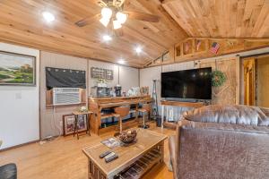 een woonkamer met een bank en een flatscreen-tv bij Kentucky Countryside Cabin Near Fort Campbell in Oak Grove