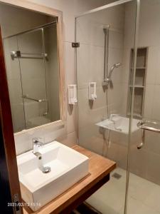 a bathroom with a sink and a glass shower at The Heritage Karawaci in Binong