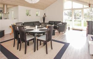 una sala da pranzo e un soggiorno con tavolo e sedie. di Beautiful Home In Haderslev With Kitchen ad Årø