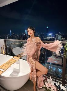 a woman in a dress standing on top of a building at Skyscraper 65 KL Highest Outdoor Bathtub Luxury Lavish Designer Penthouse in Kuala Lumpur