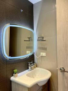 een badkamer met een wastafel en een spiegel bij Apartamento en Resort Playa Azul in Tonsupa