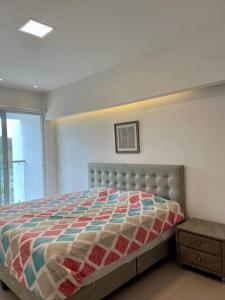 een slaapkamer met een bed met een quilt bij Apartamento en Resort Playa Azul in Tonsupa