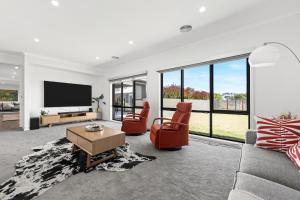 a living room with a couch and two chairs and a tv at 10BR Great Ocean farmstay for 20 people in Leopold