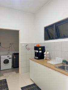 a kitchen with a sink and a washing machine at Homeseek, Spacious and Cozy Apartment in Kuala Terengganu in Kuala Terengganu