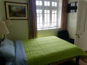 een slaapkamer met een groen bed en een raam bij Posada Casa Real in Huancayo