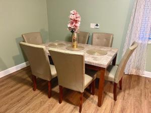 a dining room table with chairs and a vase with flowers at Utopia Luxury Stay - Seattle in Seattle