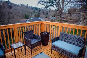 two chairs and a table on a wooden deck at Utopia Luxury Stay - Seattle in Seattle