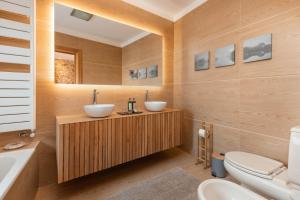 a bathroom with two sinks and a toilet and a tub at Confluentia H&A - XIII Century Loft House in Coimbra