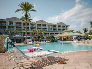 Holiday Inn Club Vacations Cape Canaveral Beach Resort في كيب كانافيرال: مسبح مع كرسي صالة ومنتجع