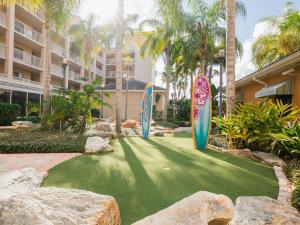 tres tablas de surf en un césped artificial frente a un edificio en Holiday Inn Club Vacations Cape Canaveral Beach Resort, en Cabo Cañaveral