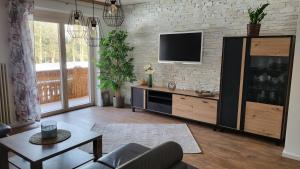 ein Wohnzimmer mit einem TV an einer Backsteinwand in der Unterkunft Relax FeWo in Bayerisch Gmain