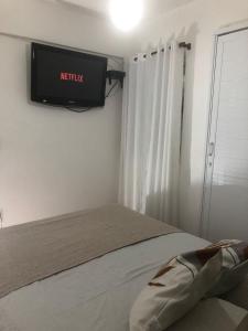 Casa para 4 pessoas RJ - Wiffi 500 mb في ريو دي جانيرو: غرفة نوم مع سرير وتلفزيون على الحائط