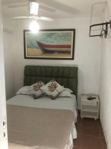 a bedroom with a bed with a painting of a boat at Casa para 4 pessoas RJ - Wiffi 500 mb in Rio de Janeiro