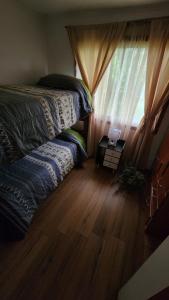 1 dormitorio con cama y ventana con ordenador portátil en Cabañas Tronco viejo, en La Serena