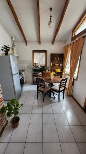 een keuken met een tafel en stoelen en een koelkast bij Cabañas Tronco viejo in La Serena
