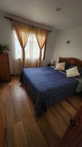 1 dormitorio con 1 cama con edredón azul en Cabañas Tronco viejo, en La Serena