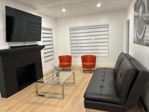 - un salon avec un canapé en cuir noir et une cheminée dans l'établissement Sri House, à Miami