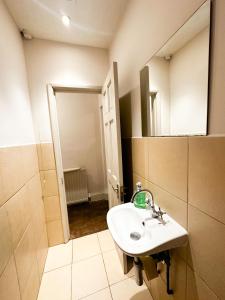 a bathroom with a sink and a mirror at 58 Alloa townhouse in London