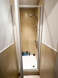 a bathroom with a shower with a tub and a shower at 58 Alloa townhouse in London