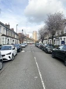 a street with cars parked on the side of the road at 58 Alloa townhouse in London