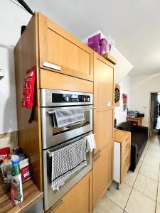 a kitchen with stainless steel ovens in a wooden cabinet at 58 Alloa townhouse in London