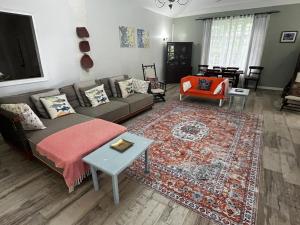 a living room with a couch and a rug at Rafeen villa- Historic villa with pool in Bridgetown