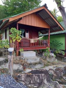 una casa con porche y escaleras delante en Easy Life Bungalows, en Haad Yao