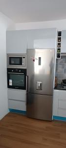 La cuisine est équipée d'un réfrigérateur et d'un four micro-ondes. dans l'établissement Residência Águia, à Praia