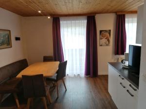 a dining room with a wooden table and a television at Steinerbauer in Flachau