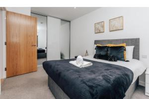 a bedroom with a large bed with a wooden door at New Deluxe Birmingham City Centre Apartment 3 Bed in Birmingham