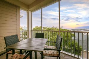eine Veranda mit einem Holztisch und Stühlen auf dem Balkon in der Unterkunft Holiday Inn Club Vacations South Beach Resort in Myrtle Beach