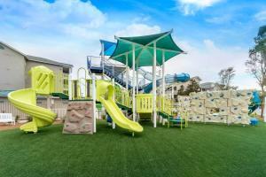 a playground with a slide on a lawn at Holiday Inn Club Vacations South Beach Resort in Myrtle Beach