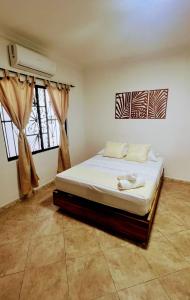 a bedroom with a bed and two windows at LIVE APARTMENTS Cartagena in Cartagena de Indias