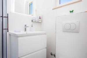 a white bathroom with a sink and a mirror at Apartment Duce 2778b in Duće