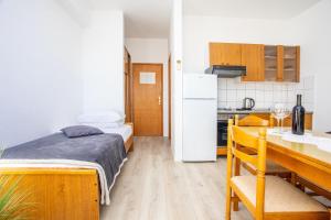 a small room with a bed and a kitchen at Apartment Duce 2778b in Duće