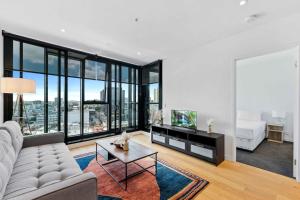 un soggiorno con un divano e una TV di Modern 1BR Apt with Gym Pool & Wifi a Brisbane