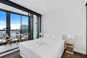 una camera da letto con un letto bianco e una grande finestra di Modern 1BR Apt with Gym Pool & Wifi a Brisbane