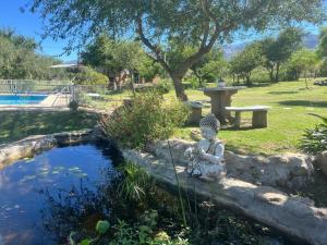 a statue of a woman sitting next to a pond at Flor Silvestre in Carpintería