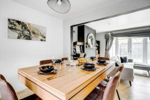 een eetkamer met een houten tafel en stoelen bij Modern Warm 4 Bedroom House in Kirkby