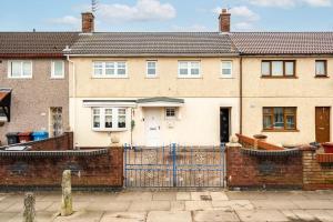 a large brick house with a blue fence at Modern Warm 4 Bedroom House in Kirkby