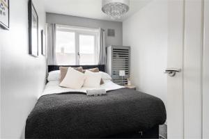 a bedroom with a bed with white pillows and a window at Modern Warm 4 Bedroom House in Kirkby