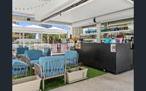 un restaurant avec des chaises bleues et un comptoir avec des boissons dans l'établissement Level 27 Oceanview Apt In Hilton-Signed Building, à Gold Coast