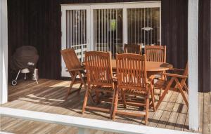 a wooden table and chairs on a deck at Three-Bedroom Holiday Home In Sydals in Skovbyballe