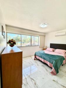 um quarto com uma cama e uma cómoda com um vaso em Ed Canoa Apartamentos Temporada em Maceió
