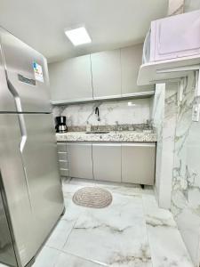 uma cozinha com um frigorífico em aço inoxidável e bancadas em mármore em Ed Canoa Apartamentos Temporada em Maceió