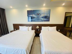 two beds sitting next to each other in a room at MARINA Bình Dương in Ấp Phú Thọ