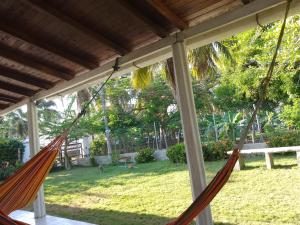 two hammocks hanging from a porch with a yard at Mágica Cabaña familiar cerca al mar in Coveñas