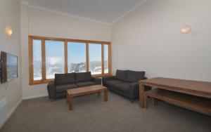 a living room with two couches and a table at Smiggins Hotel & Chalet Apartments in Perisher Valley