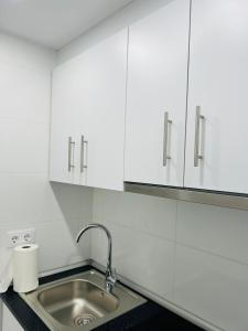 a kitchen with a sink and white cabinets at Estudio a 100 m del mar in Vinaròs +12 photos
